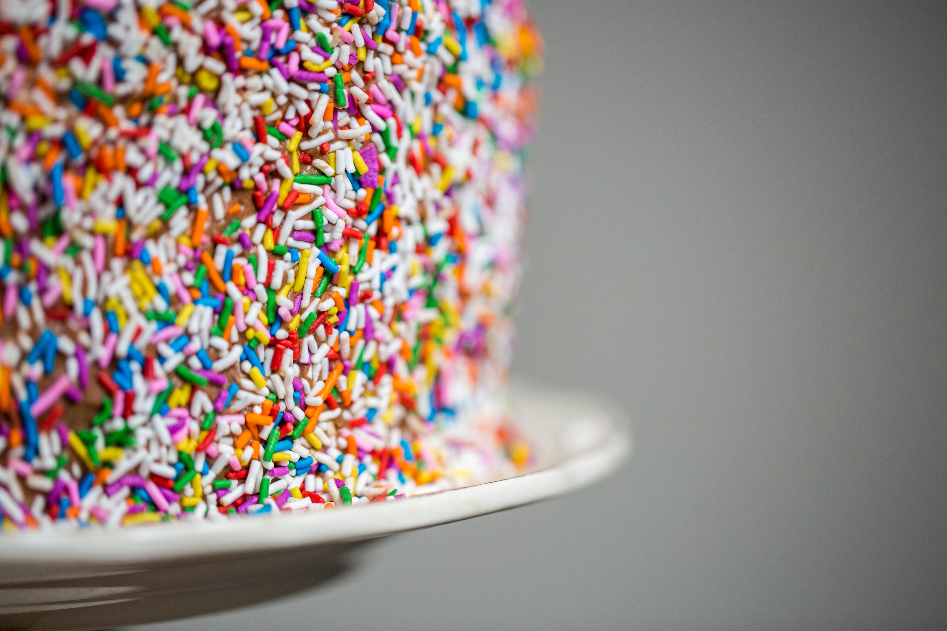 Close of view of the side of a cake covered in sprinkles