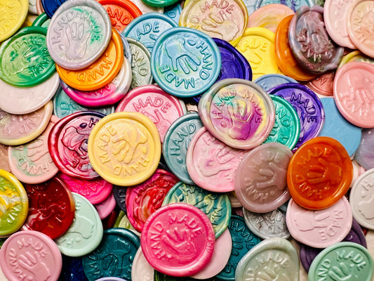 "Hand Made" wax seal stickers in a pile, in various colors.