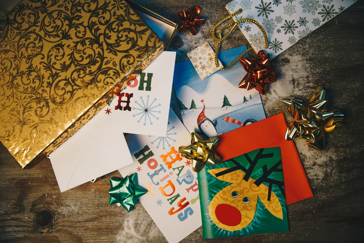 Image if Christmas gift wrap displayed on a wooden surface and faux snow