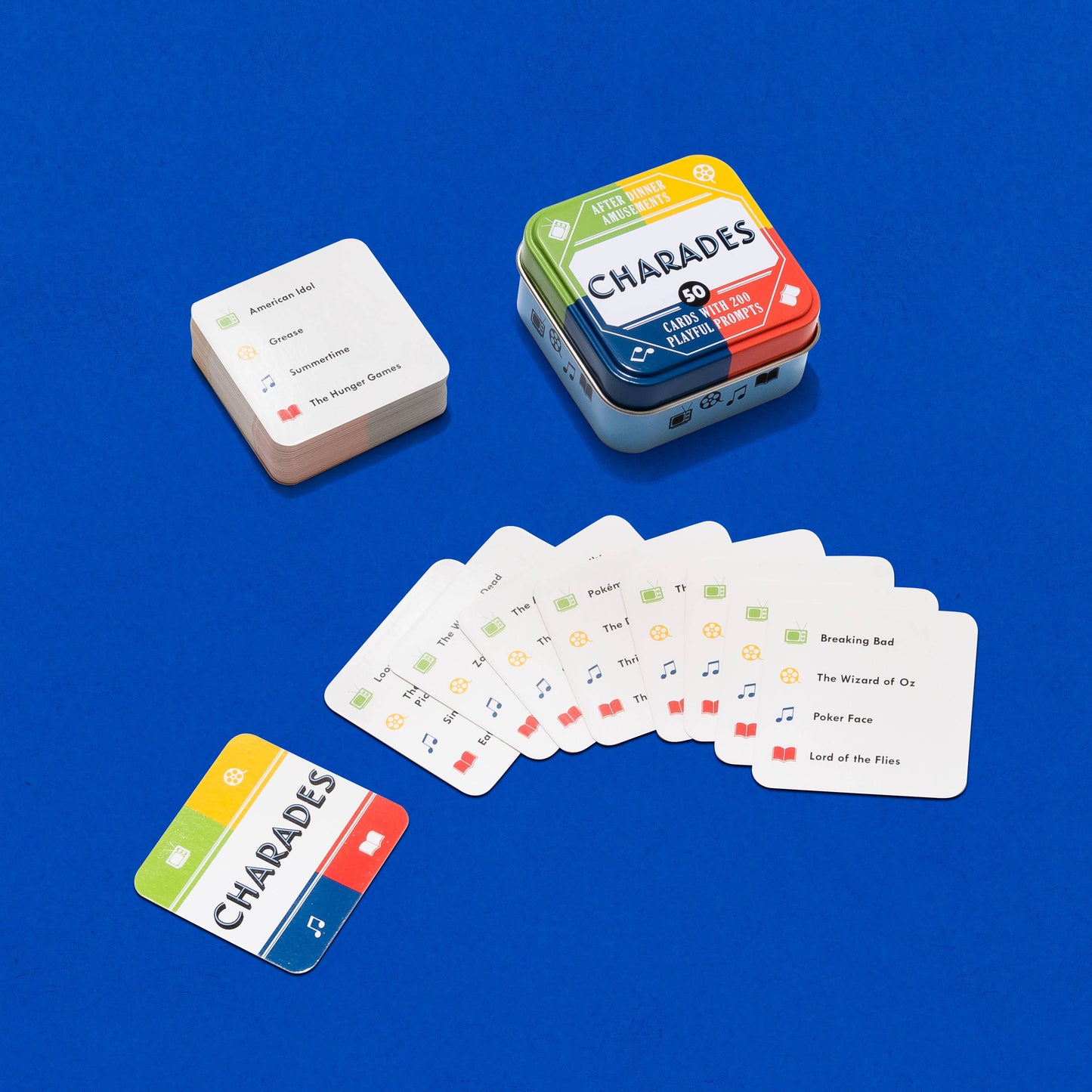 Charades card game with cards and tin on a blue background