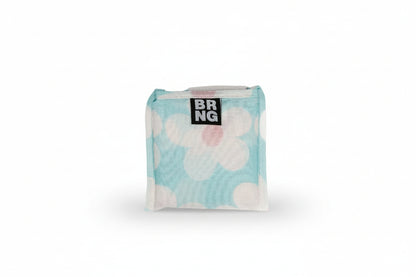Dolly Daily BRNG Shopper Mini with white daisies and a blue background folded into its compact size on a white background.