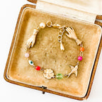 Close-up of coral, pearl, and evil eye charm on handmade bracelet