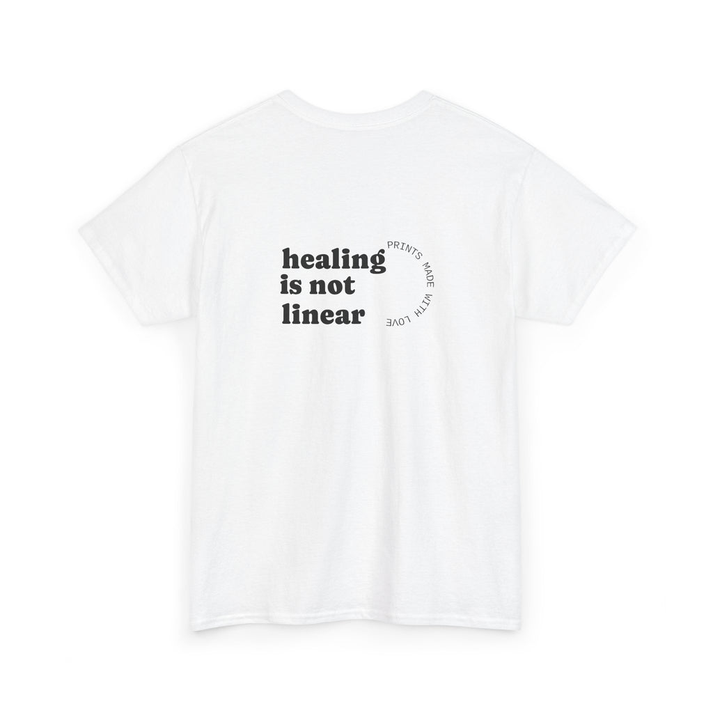 White t-shirt with 'healing is not linear' text on a white background
