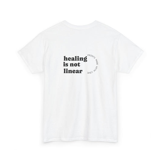 White t-shirt with 'healing is not linear' text on a white background