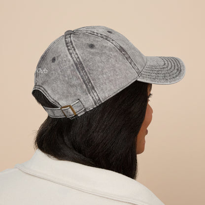 Person wearing a gray denim cap on a white background