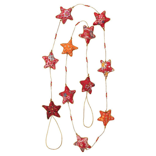 Close-up of cotton fabric stars in warm red, yellow, and orange tones with gold beading