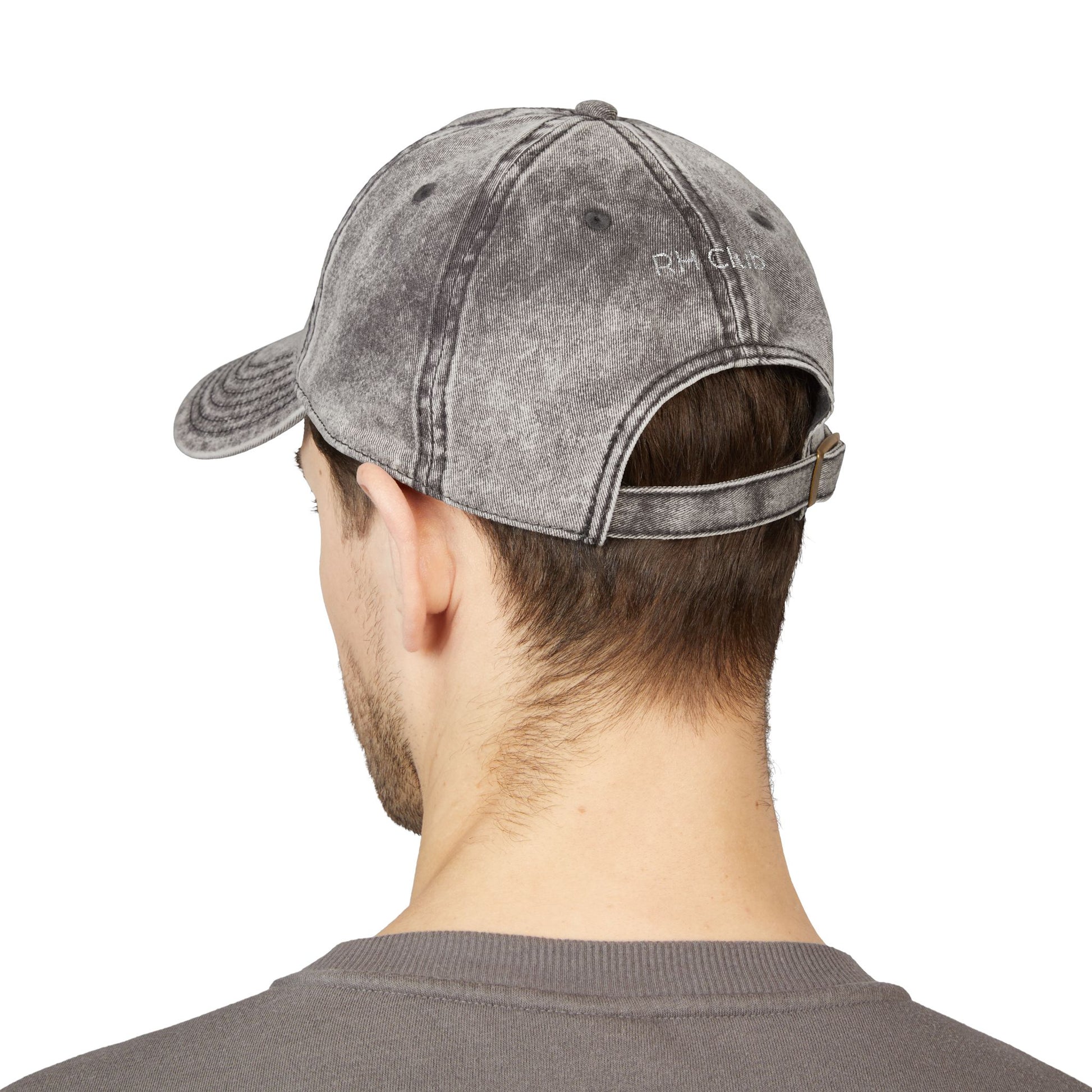 Person wearing a gray denim cap on a white background showcasing the back of the hat