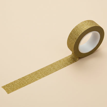 Roll of gold glitter tape on a white background