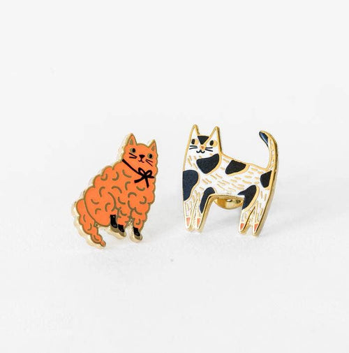 A pair of earrings featuring artistic depictions of two cats in different colors, one orange and one black and white, with gold gilding.