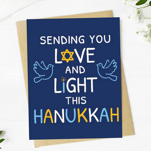 Hanukkah card with text 'Sending you love and light this Hanukkah' on a blue background with a star of David, doves, and colorful letters.