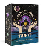 Tarot card set packaging with hands holding a colorful card against a starry night sky.
