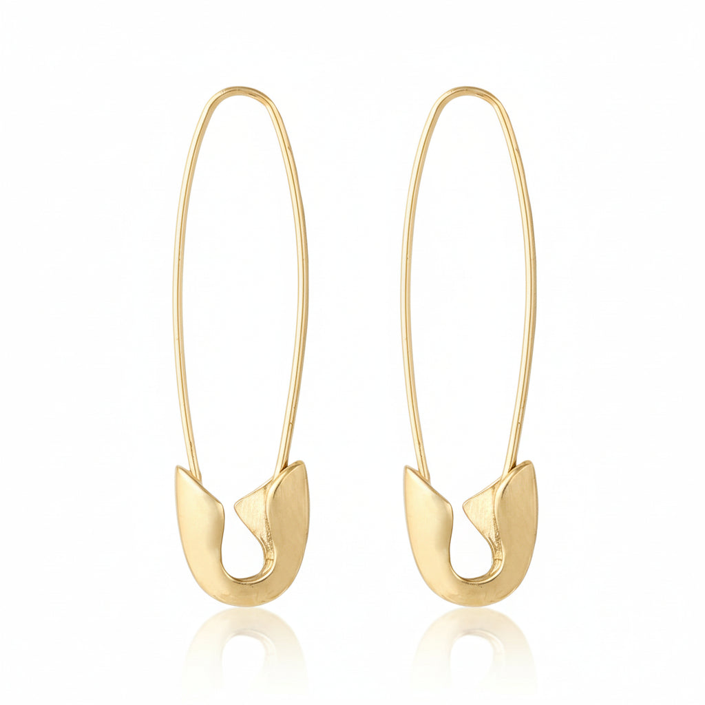 Gold safety pin earrings on a white background.