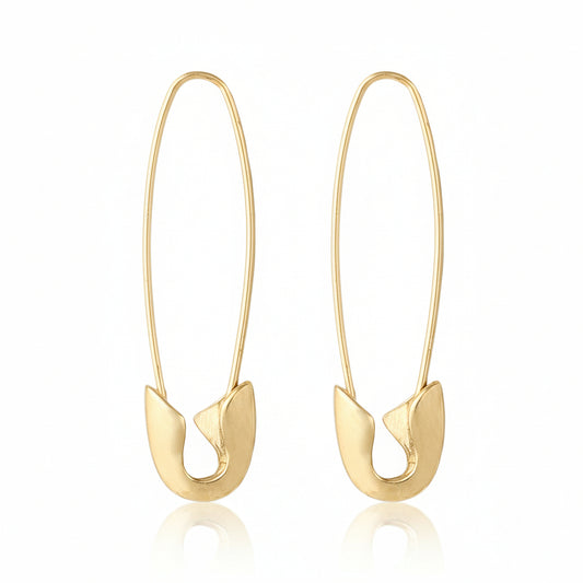 Gold safety pin earrings on a white background.