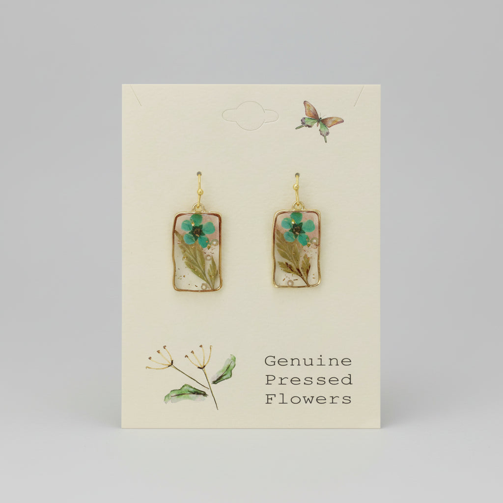 Pair of earrings with pressed flowers on a card labeled 'Genuine Pressed Flowers'.