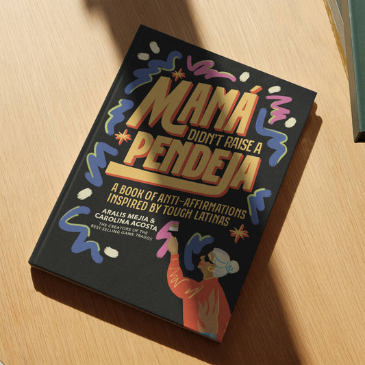 Book titled 'Mama Didn't Raise a Pendeja' on a wooden surface