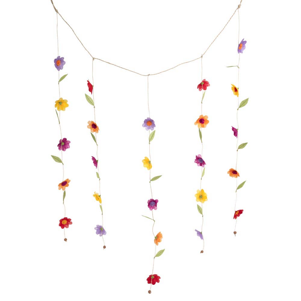 Silk paper flower valance hanging against a white wall with five cascading floral strands