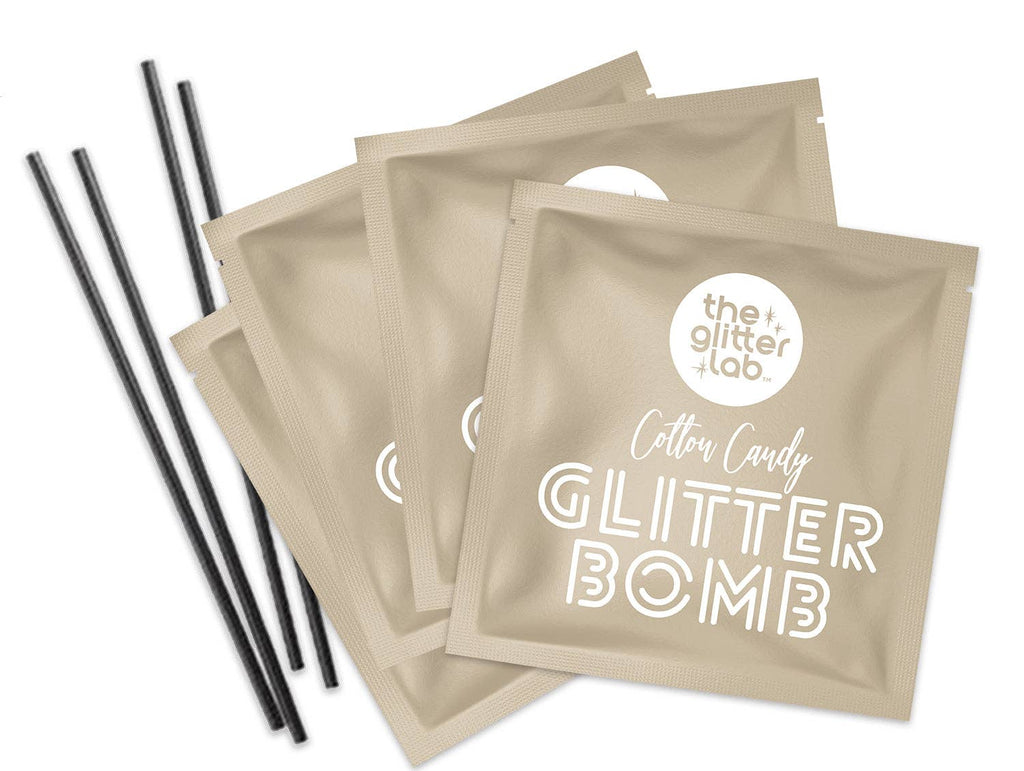 Close up of the four packages of Cotton Candy Gold Glitter Bomb and stir straws provided. 