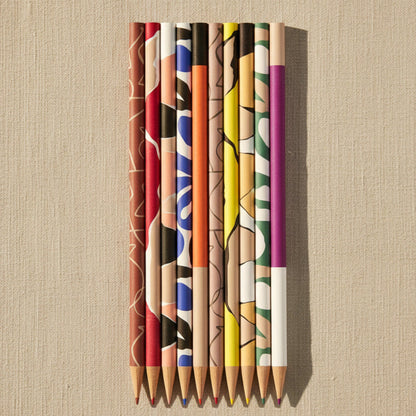 Set of watercolor pencils with abstract designs on a light blue background