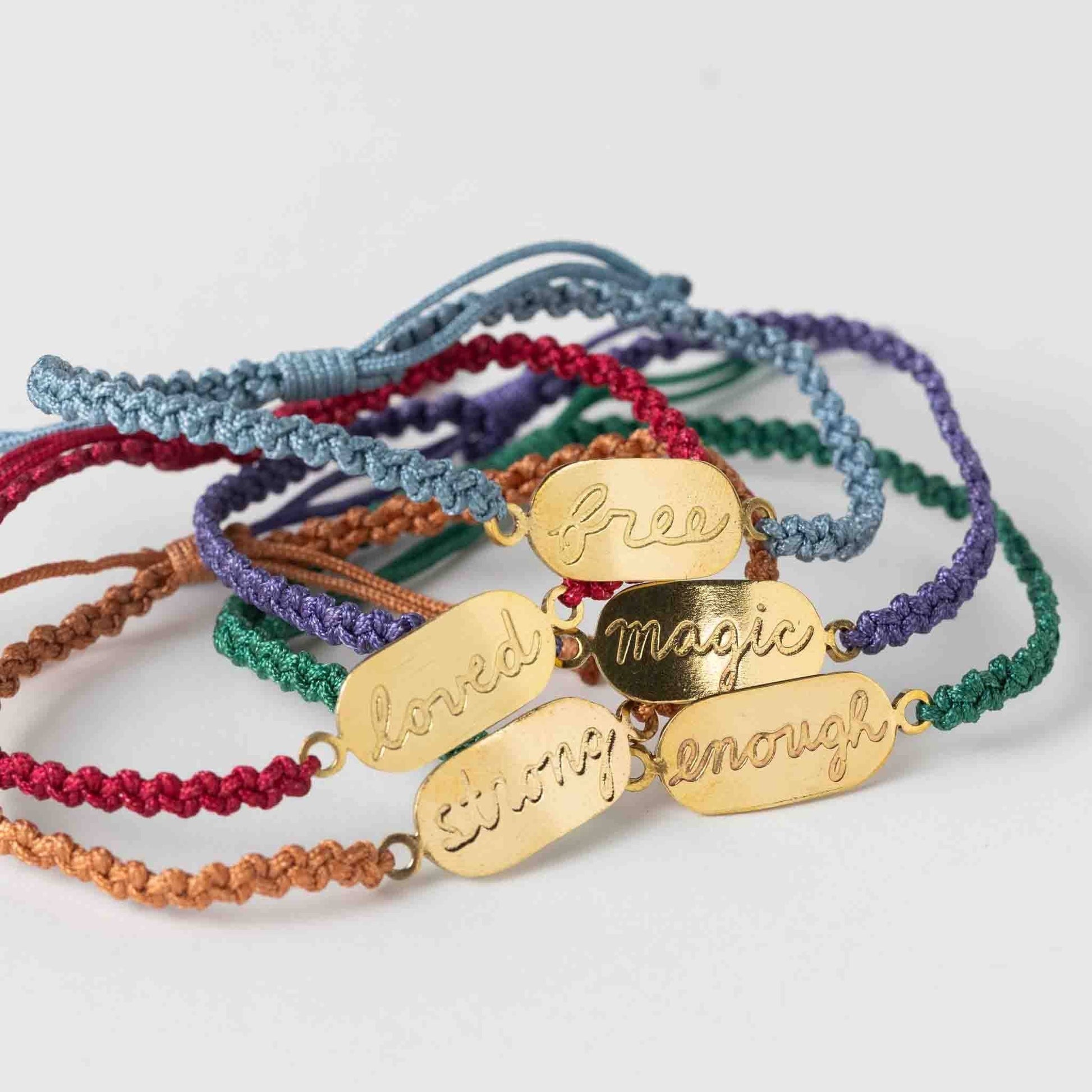 Colorful bracelets with gold tags on a white background