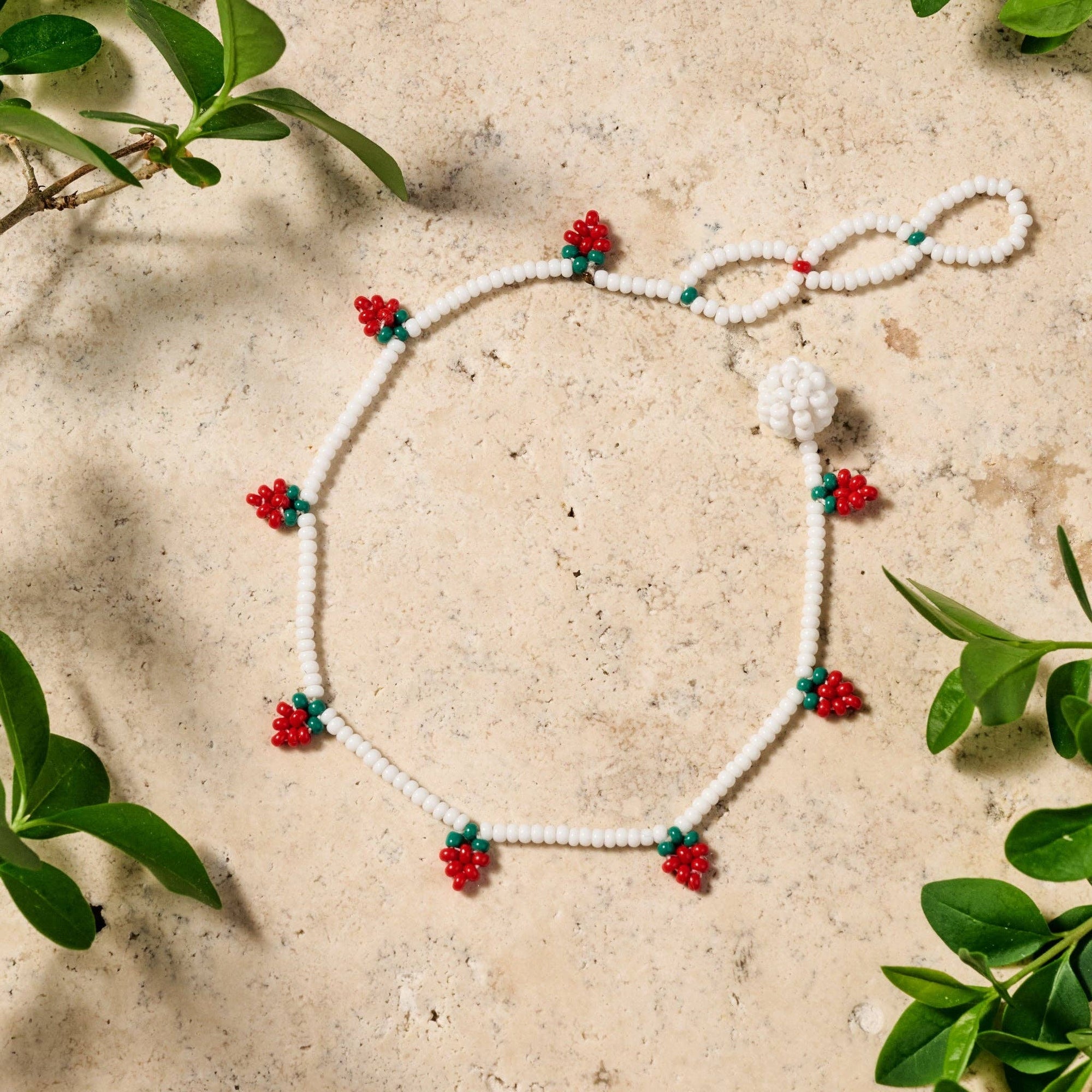 Hand-beaded Taja bracelet with strawberry motif on soft cotton thread, adjustable closure visible