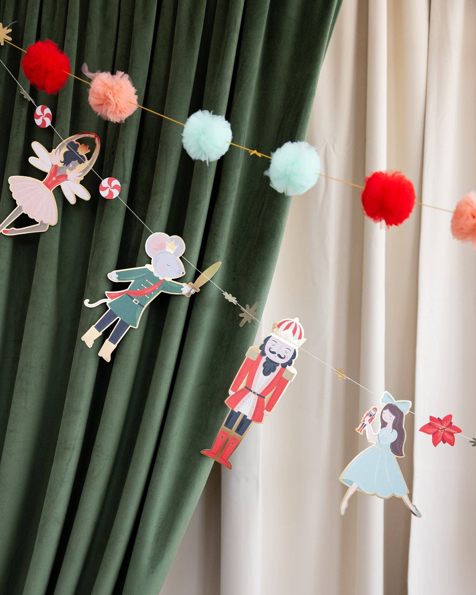 Decorative garland with paper cutouts of characters against a curtain background