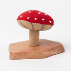 Bright red fabric mushroom with natural base on white backdrop