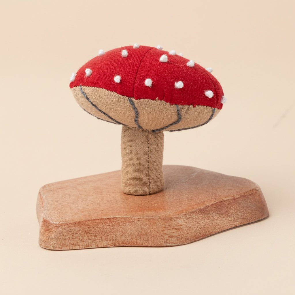 Bright red fabric mushroom with natural base on white backdrop