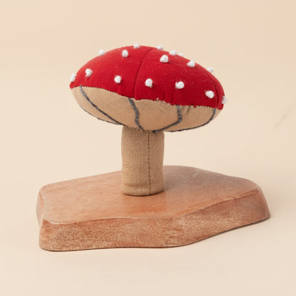 Bright red fabric mushroom with natural base on white backdrop