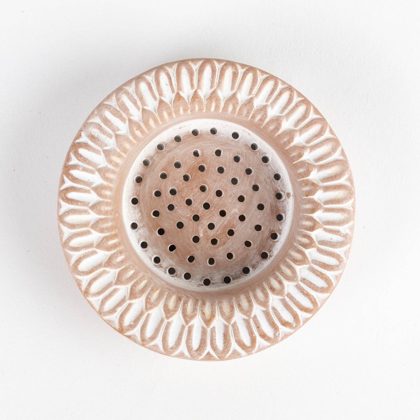Decorative ceramic strainer with intricate design on a white background