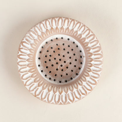 Decorative ceramic strainer with intricate design on a white background