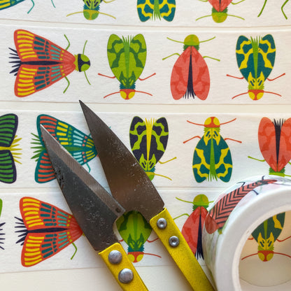 Close up image of Mondo Bug washi tape unrolled and next to scissors