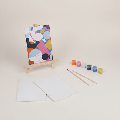 Artistic painting set with a colorful abstract painting on an easel, paint containers, brushes, and blank paper.