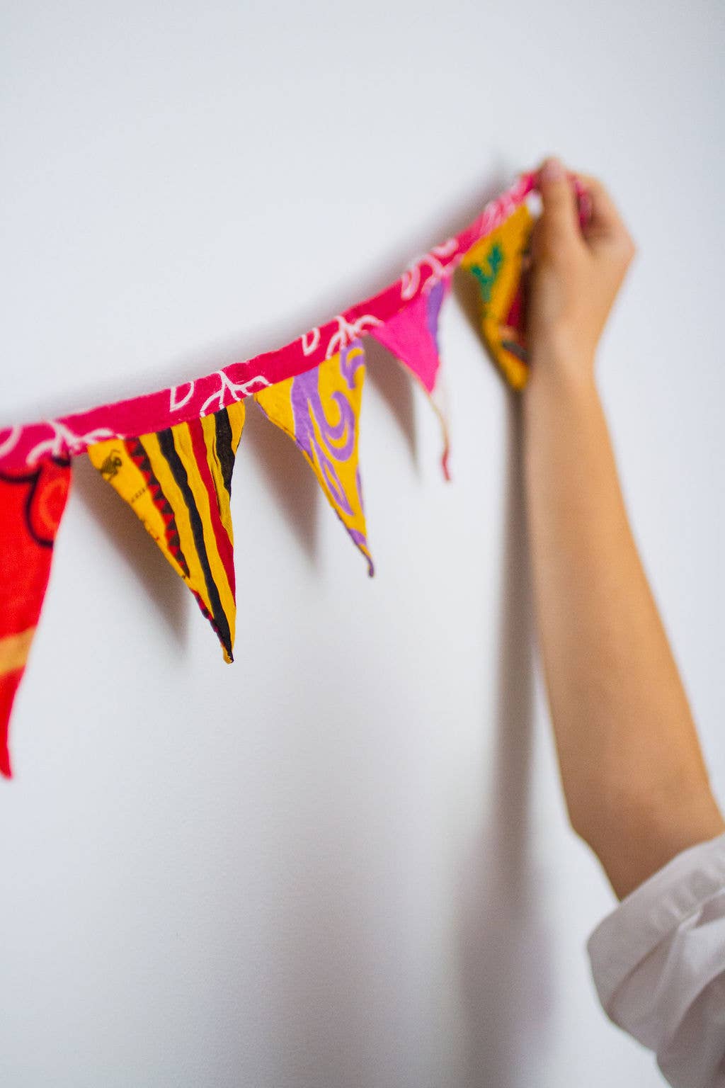 Close-up of assorted triangle flags made from vibrant sari fabric with unique patterns