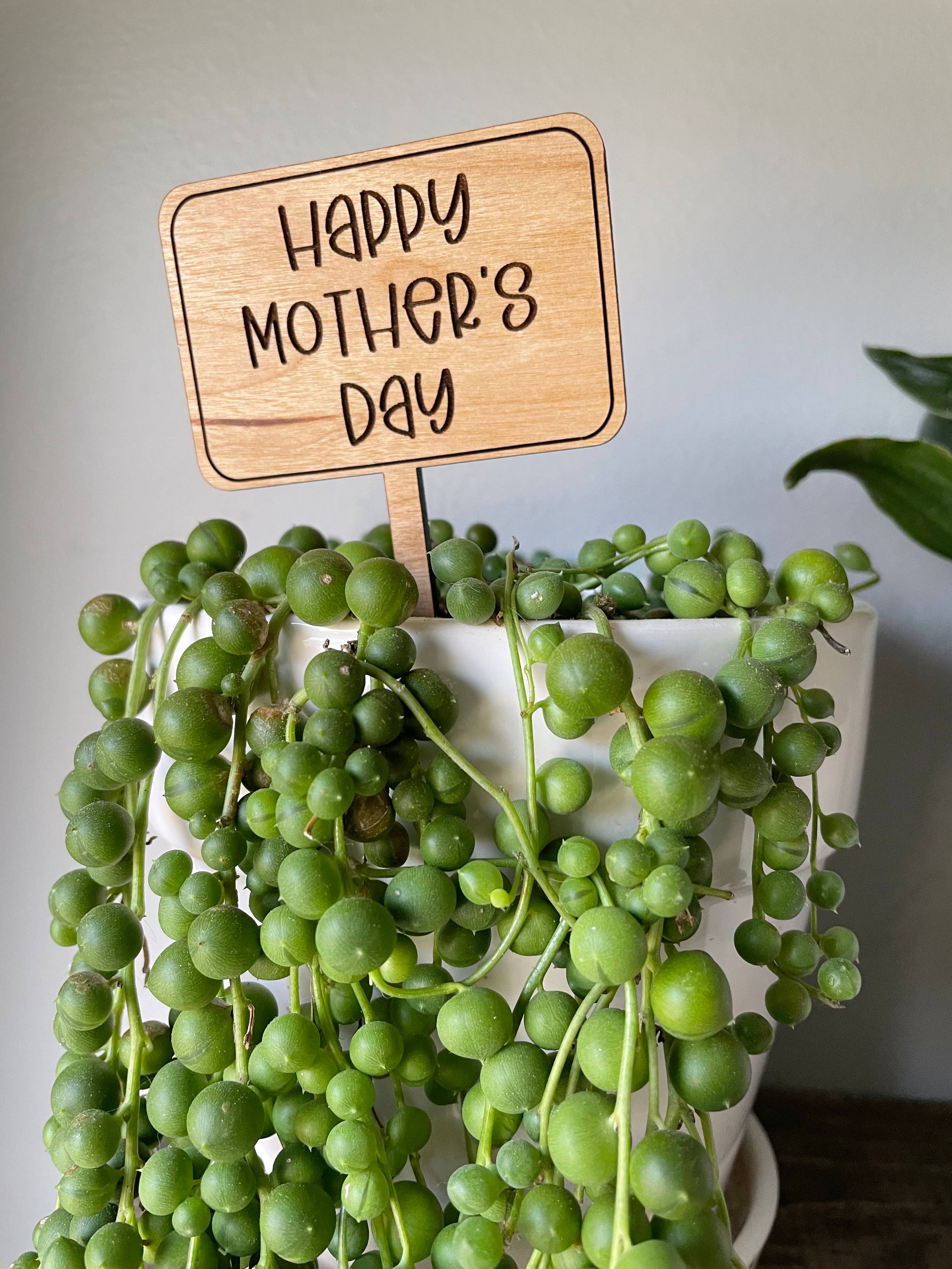Cherry hardwood plant marker engraved with a heartfelt message, placed in a flower pot.