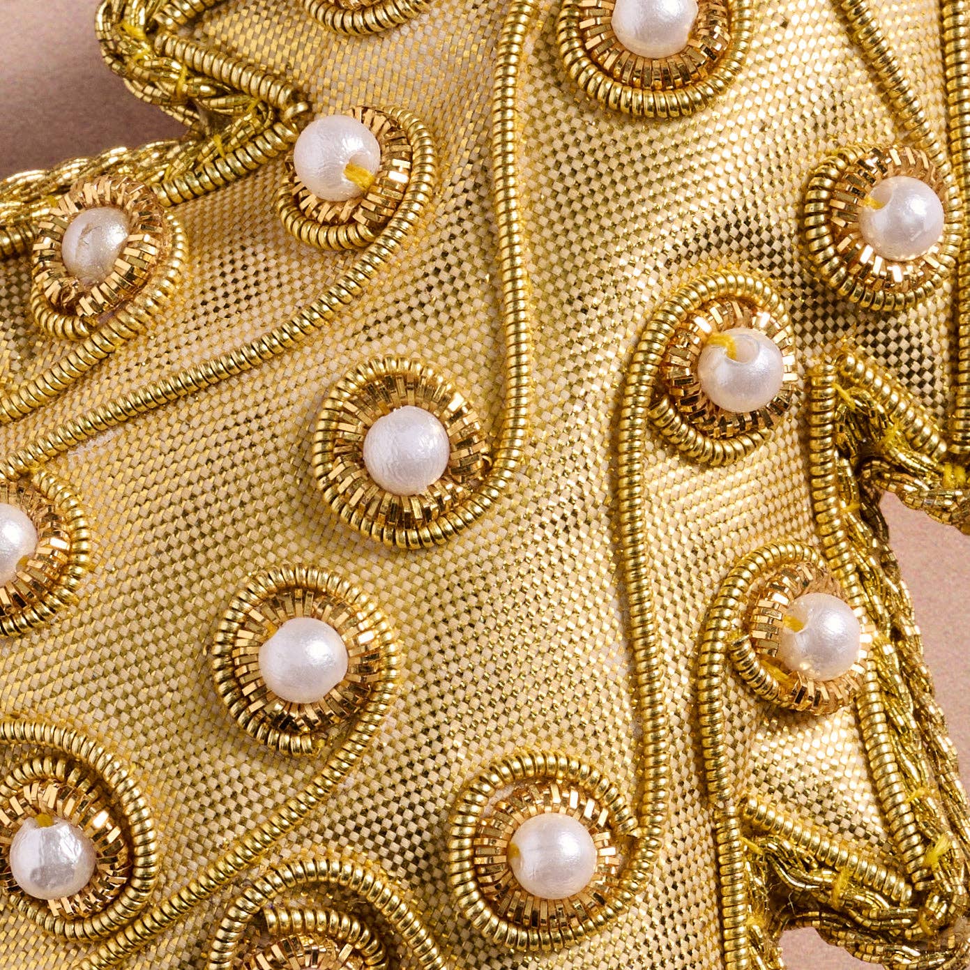 Close-up of gold fabric with pearl-like bead embellishments