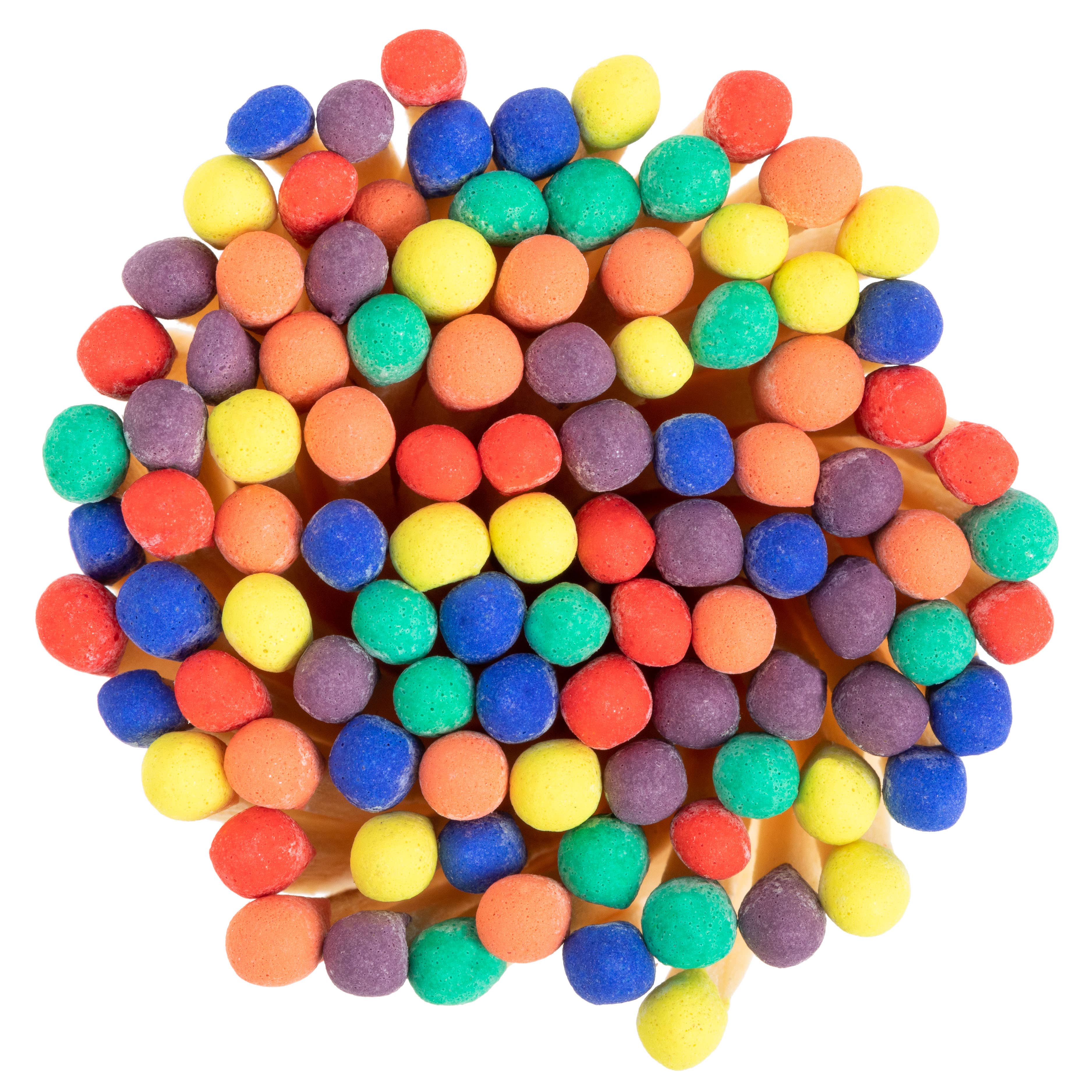 Rainbow-colored wooden matchsticks in a corked glass vial – vibrant matches perfect for candles, wedding favors, and gifts. Close up image of match sticks. 
