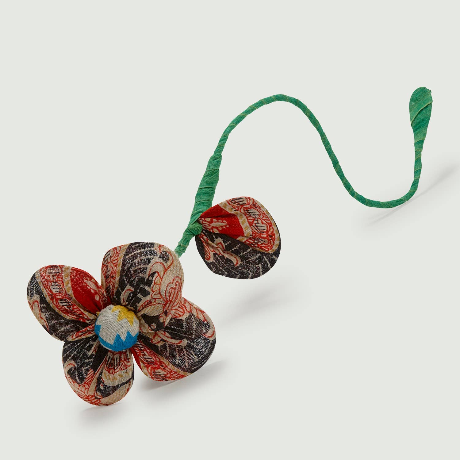 Brightly colored recycled sari flower with bendable stem on white background