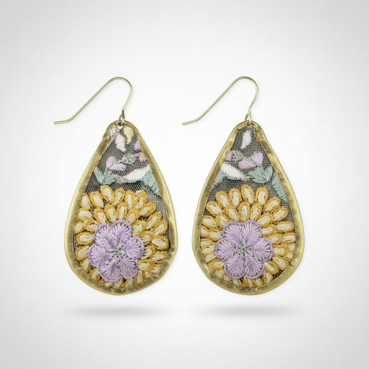 Teardrop-shaped earring with floral design on a white background