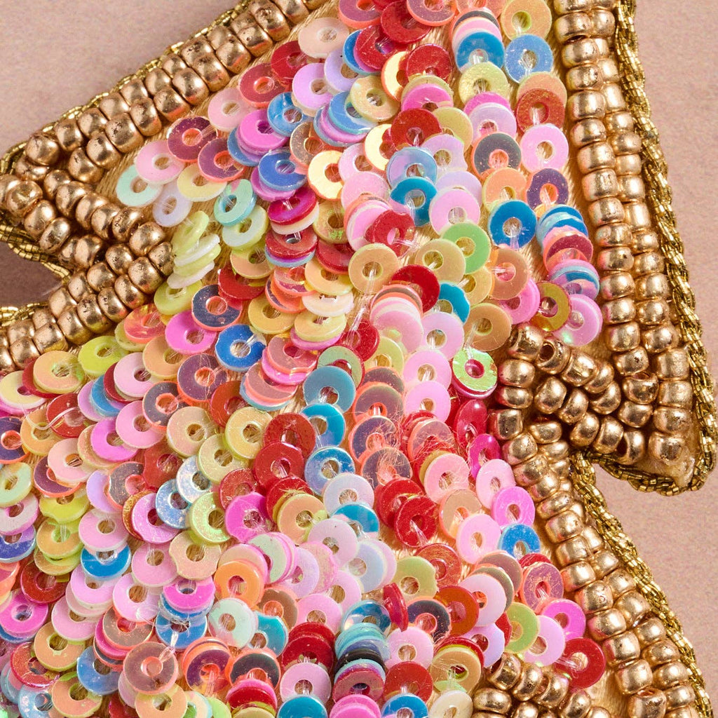 Multicolored sequin ornament with gold trim on a beige background