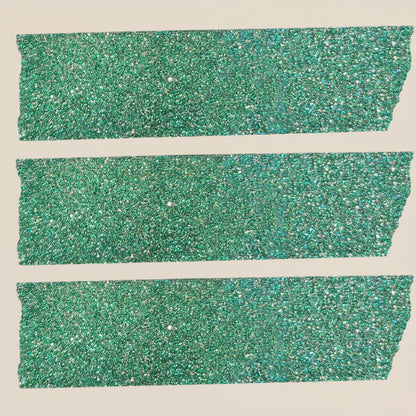 Green glittery washi tape added to holiday gift wrap with holiday packages and other elements on a light beige background