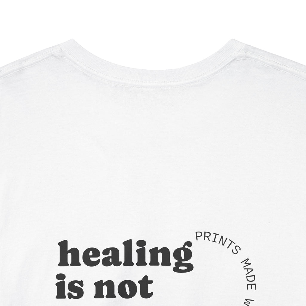 White t-shirt with 'healing is not' text on a white background and showing off the comfort collar
