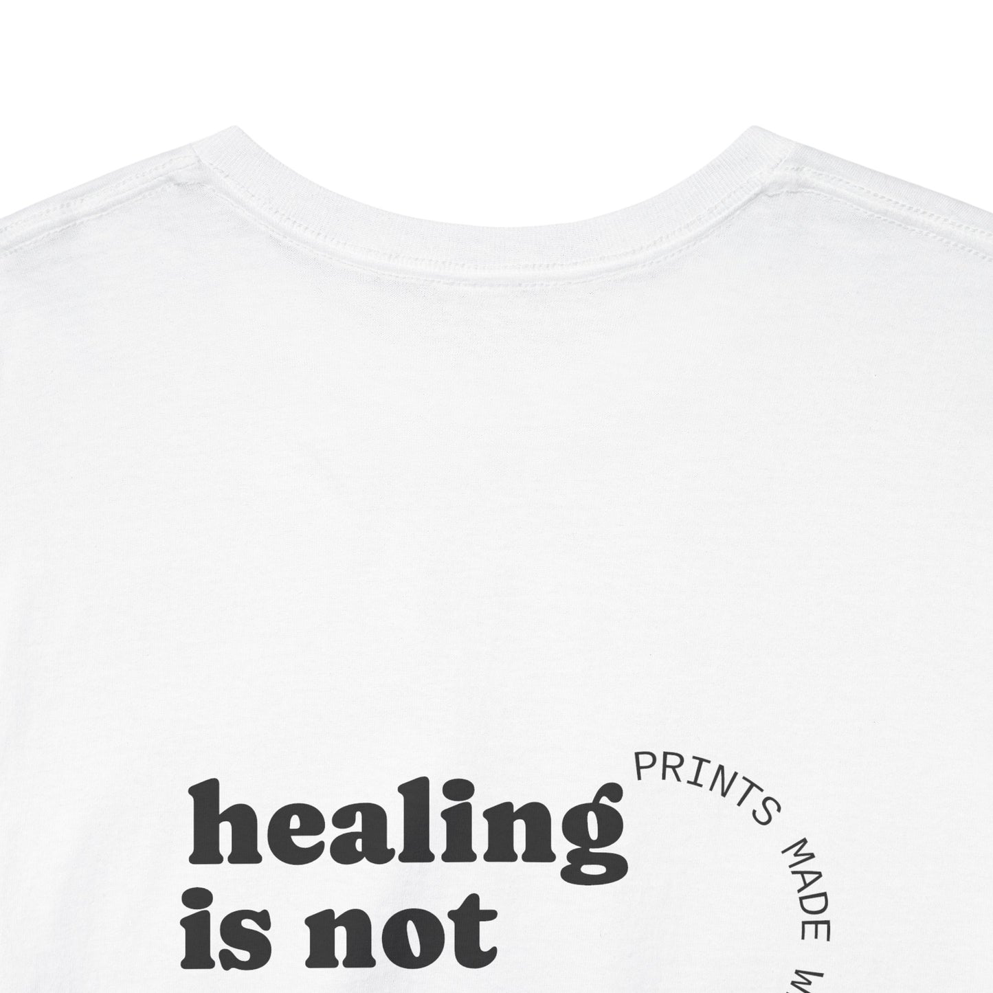 White t-shirt with 'healing is not' text on a white background and showing off the comfort collar