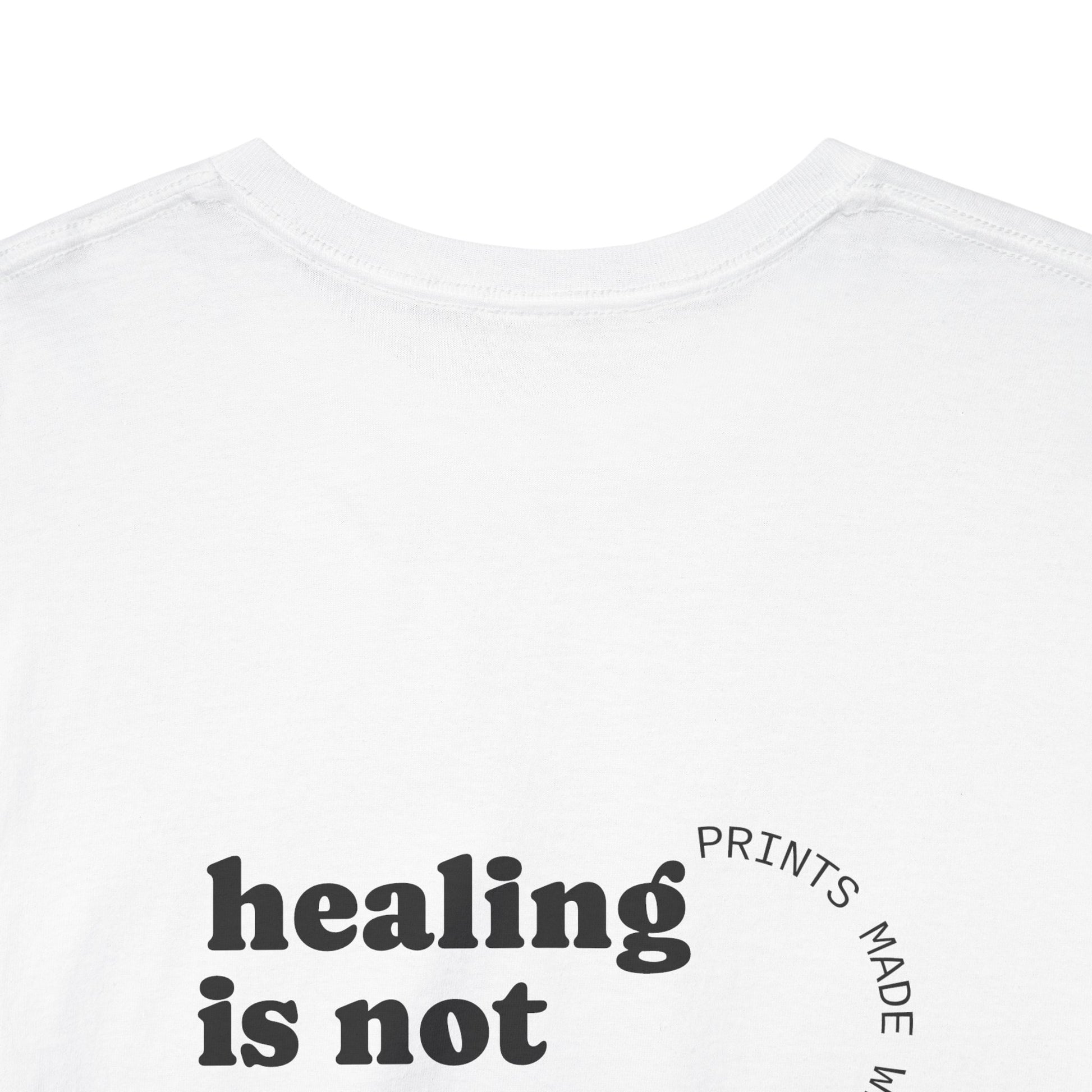 White t-shirt with 'healing is not' text on a white background and showing off the comfort collar