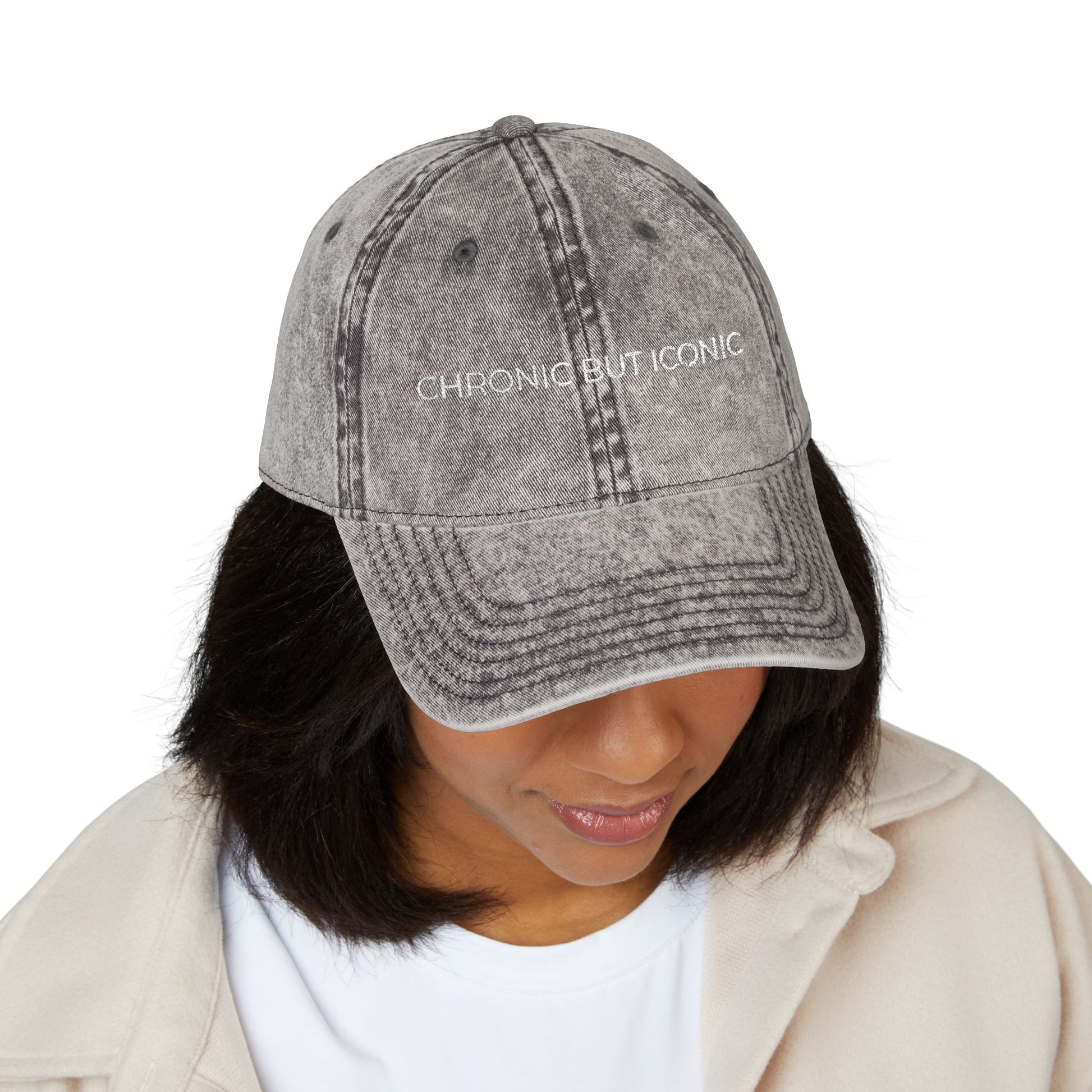 Person wearing a gray denim cap with 'Chronic But Iconic' text on a white background