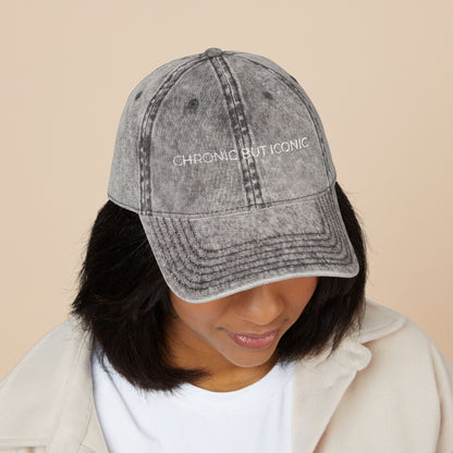 Person wearing a gray denim cap with 'Chronic But Iconic' text on a white background