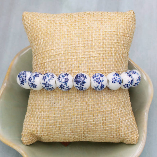Bracelet with blue floral pattern on a textured beige pillow