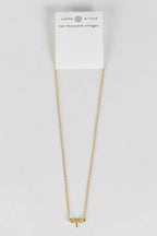 Delicate dragonfly charm necklace resting on neutral surface, handmade in India