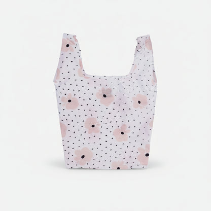 Compact tote bag with a blush pink floral pattern on a black speckled background.