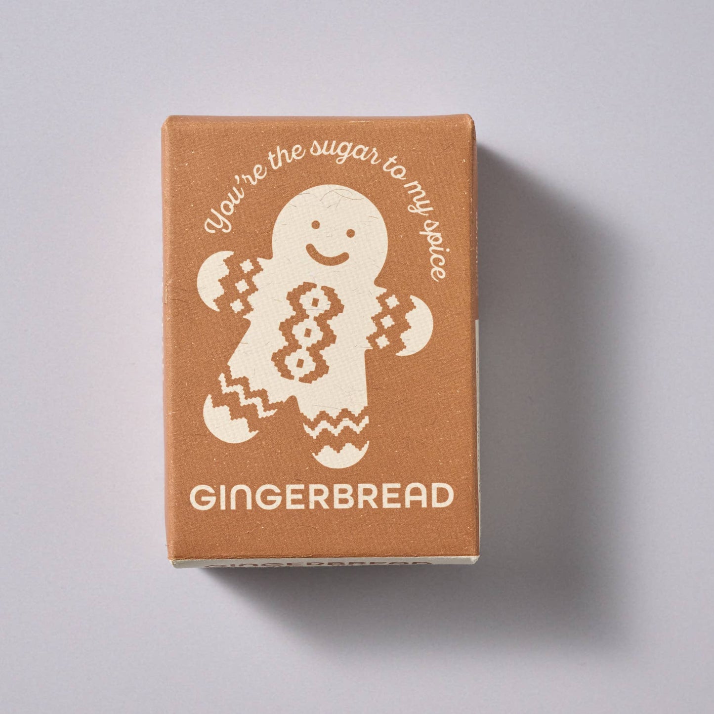 Gingerbread-themed product packaging with a gingerbread man illustration on a light gray background