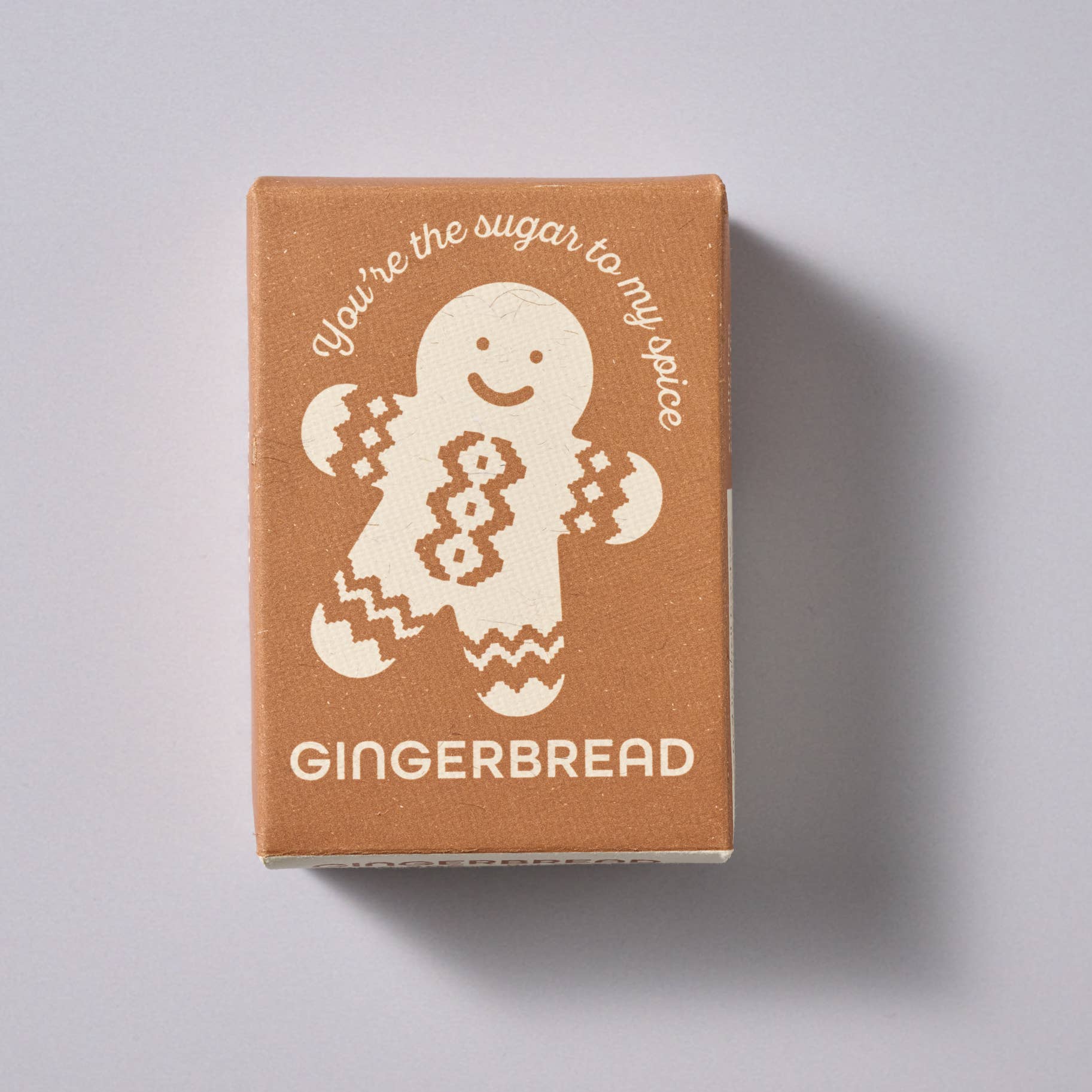 Gingerbread-themed product packaging with a gingerbread man illustration on a light gray background